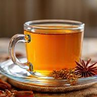 Saffron chai in glass teacup with spice garnish