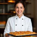 Pastry Chef Sena Gül smiling with tray of baklava